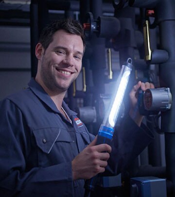 An LED work lamp helps a man to see more clearly while he is fixing a car