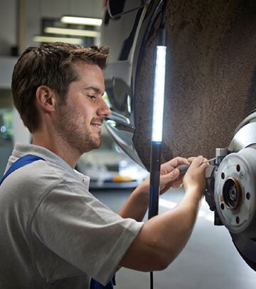 An LED work lamp helps a man to see more clearly while he is fixing a car